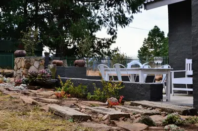 a garden with white chairs and a table at Salt on Dullstroom in Dullstroom