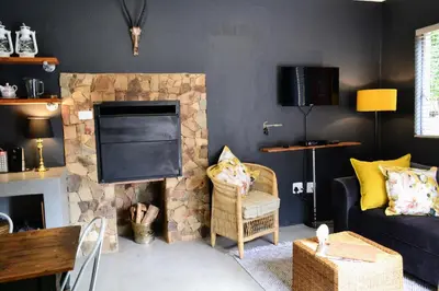 a living room with a couch and a stone fireplace at Salt on Dullstroom in Dullstroom