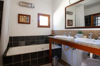 a bathroom with two sinks and a tub and a mirror at Sanctuary in Dullstroom