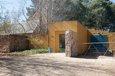 a yellow building with a gate and a fence at Sanctuary in Dullstroom