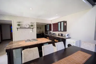 a kitchen with a table and chairs in a kitchen at Sorgenvrei in Dullstroom