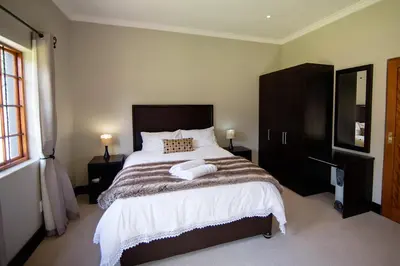 a bedroom with a large bed with two towels on it at Sorgenvrei in Dullstroom