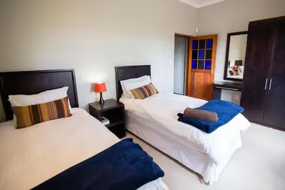 a bedroom with two beds with blue towels on them at Sorgenvrei in Dullstroom