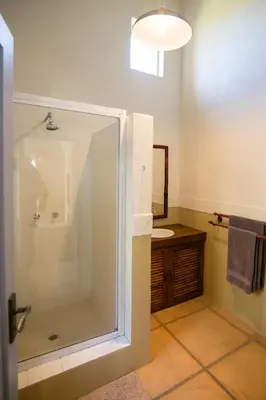 a bathroom with a shower and a toilet and a sink at Waterval in Dullstroom