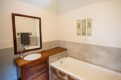 a bathroom with a sink and a tub and a mirror at Waterval in Dullstroom