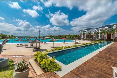 a pool at a resort with umbrellas and tables at THE BLYDE LAGOON BEACH PRETORIA 3 BEDROOM GROUND FLOOR APARTMENT in Pretoria