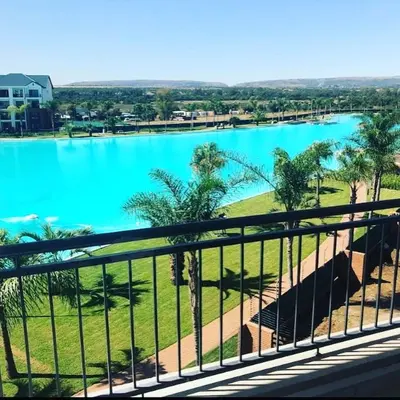 a view of a large pool of water from a balcony at THE BLYDE LAGOON BEACH PRETORIA 3 BEDROOM GROUND FLOOR APARTMENT in Pretoria