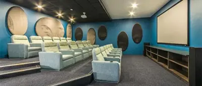 a room with a bunch of chairs and a screen at THE BLYDE LAGOON BEACH PRETORIA 3 BEDROOM GROUND FLOOR APARTMENT in Pretoria