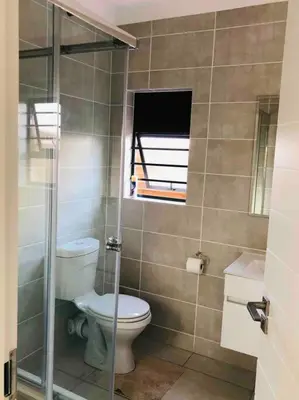 a bathroom with a toilet and a window at THE BLYDE LAGOON BEACH PRETORIA 3 BEDROOM GROUND FLOOR APARTMENT in Pretoria