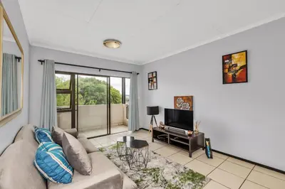a living room with a couch and a tv at Smartz Apartment 76 in Midrand