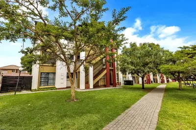 a tree in the grass in front of a building at Smartz Apartment 76 in Midrand