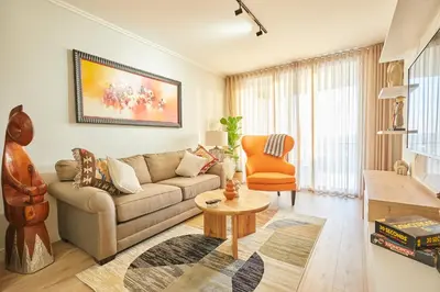 a living room with a couch and a table at Aburi at Ellipse Waterfall in Midrand