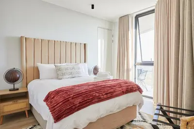 a bedroom with a large bed and a large window at Aburi at Ellipse Waterfall in Midrand