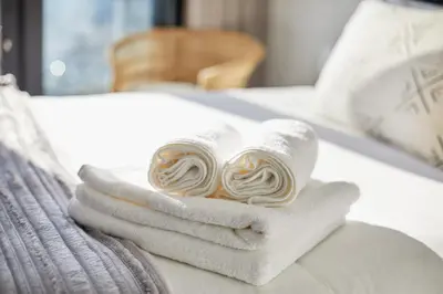 a pile of towels sitting on top of a bed at Aburi at Ellipse Waterfall in Midrand