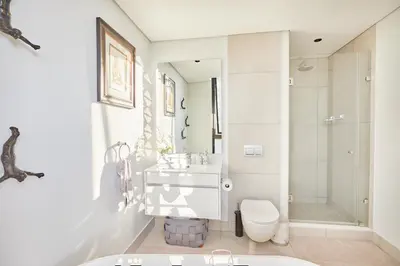 a bathroom with a sink and a toilet and a shower at Aburi at Ellipse Waterfall in Midrand