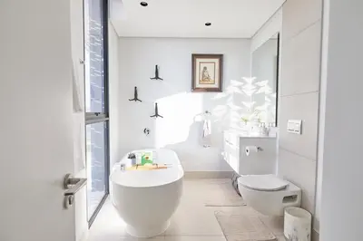 a white bathroom with a sink and a toilet at Aburi at Ellipse Waterfall in Midrand