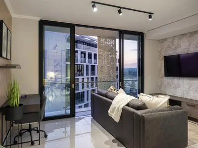 a living room with a couch and a large window at eKhaya at Ellipse Waterfall City in Midrand