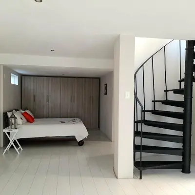 a bedroom with a bed and a staircase at Manz' amahle Guest Cottage in Hartbeespoort