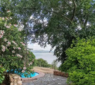 a garden with a view of the water at Manz' amahle Guest Cottage in Hartbeespoort