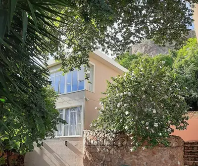 a house with a blue window and a stone wall at Manz' amahle Guest Cottage in Hartbeespoort