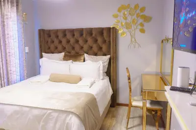 a bedroom with a large bed with white sheets at Homes of Ace 3 bedroom Villa in Pretoria