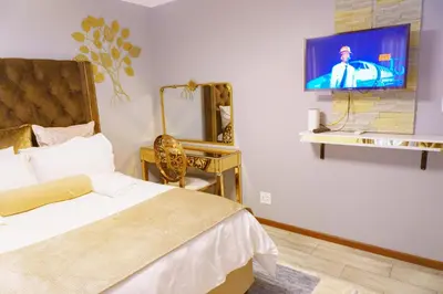 a bedroom with a bed and a tv on a wall at Homes of Ace 3 bedroom Villa in Pretoria