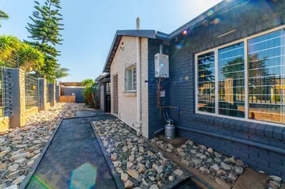 a brick house with a pathway next to a building at Homes of Ace 3 bedroom Villa in Pretoria