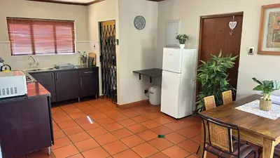 a kitchen with a table and a white refrigerator at White River Selfcatering at Greenway woods House no 9 in White River