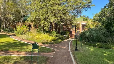 a winding path in a garden with two parking meters at White River Selfcatering at Greenway woods House no 9 in White River