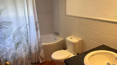 a bathroom with a toilet and a tub and a sink at White River Selfcatering at Greenway woods House no 9 in White River