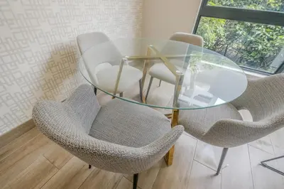 a glass dining room table with chairs and a glass table at Luxury 2BR Loft with Patio Near Menlyn at the Regency in Pretoria