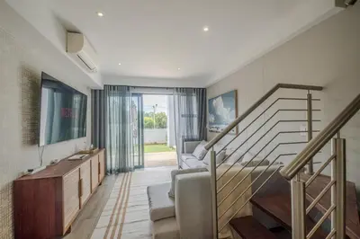 a living room with a staircase and a couch at Luxury 2BR Loft with Patio Near Menlyn at the Regency in Pretoria