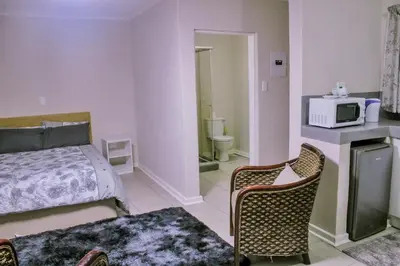 a small bedroom with a bed and a microwave at Maruleng Guest House in Hoedspruit