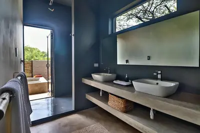 a bathroom with two sinks and a large mirror at Umkhaya in Marloth Park