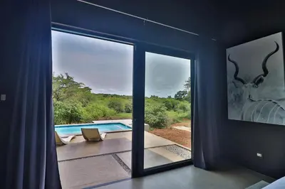 a room with a window with a view of a pool at Umkhaya in Marloth Park
