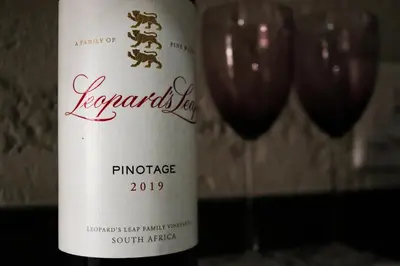 a bottle of red wine next to two wine glasses at Fair Glen in Kyalami