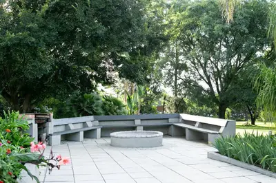 a bench in a park with trees and flowers at Fair Glen in Kyalami