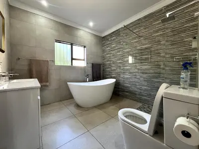 a bathroom with a tub and a toilet and a sink at Fair Glen in Kyalami