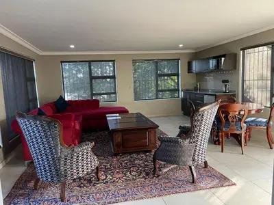 a living room with a red couch and chairs at Fair Glen in Kyalami