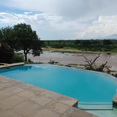 a large blue swimming pool next to a river at Buffalo Brooke in Hectorspruit