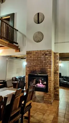 a fireplace in a living room with a fire place at Boabab Lodge in Mabula