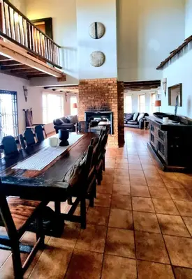 a large room with a wooden table and chairs at Boabab Lodge in Mabula
