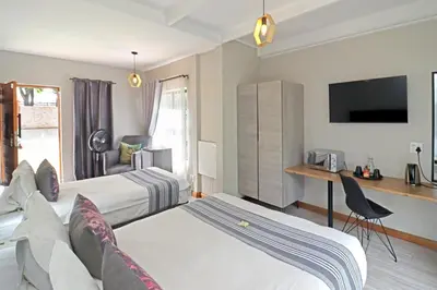 a hotel room with two beds and a tv at The Chameleon Stay @107 in Centurion