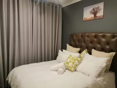 a bed with a teddy bear sitting on top of it at Centurion Cosy Apartment in Centurion