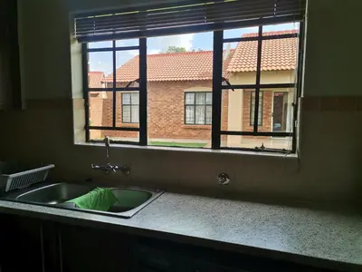 a kitchen sink in front of a window at Centurion Cosy Apartment in Centurion