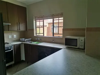 a kitchen with a microwave and a sink and a window at Centurion Cosy Apartment in Centurion