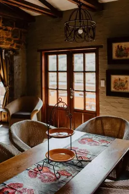 a dining room table with chairs and a wooden table at African Leaves Trout Lodge in Dullstroom