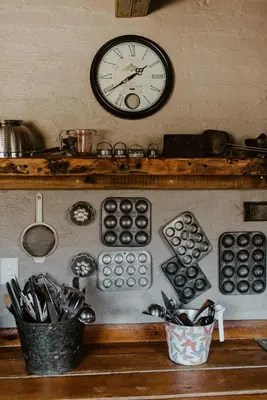 a clock on the wall above a kitchen with utensils at African Leaves Trout Lodge in Dullstroom