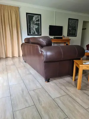 a brown leather couch in a living room at Hornbill Helipad 1 in Centurion