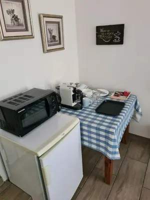 a kitchen with a table with a microwave on it at Hornbill Helipad 1 in Centurion